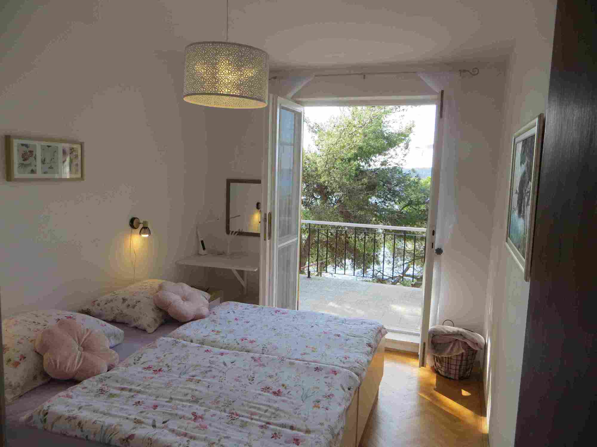 view from bedroom 1 at upper terrace with garden and seaside below