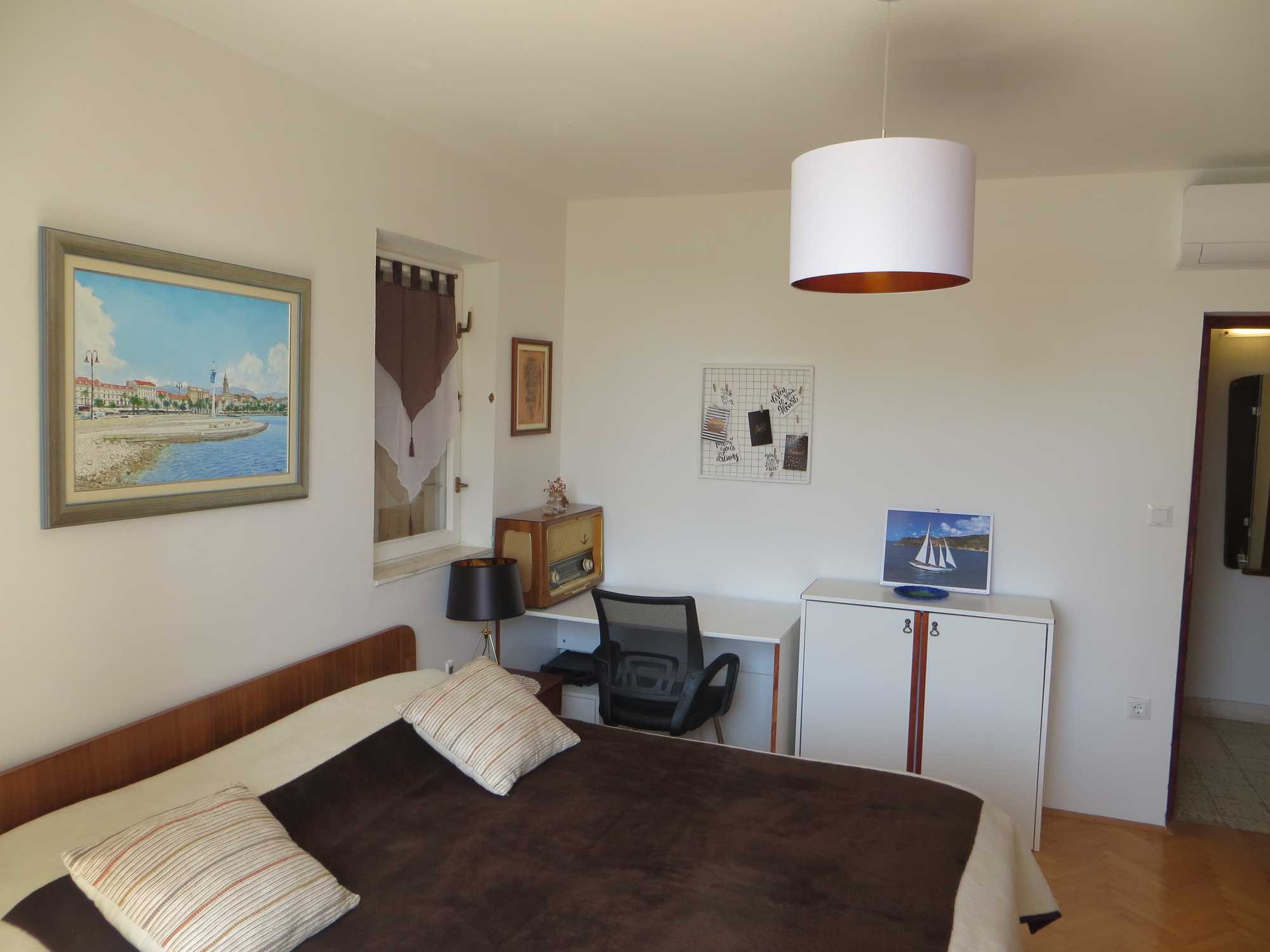 bedroom 2 with artwork, desk, and vintage elements